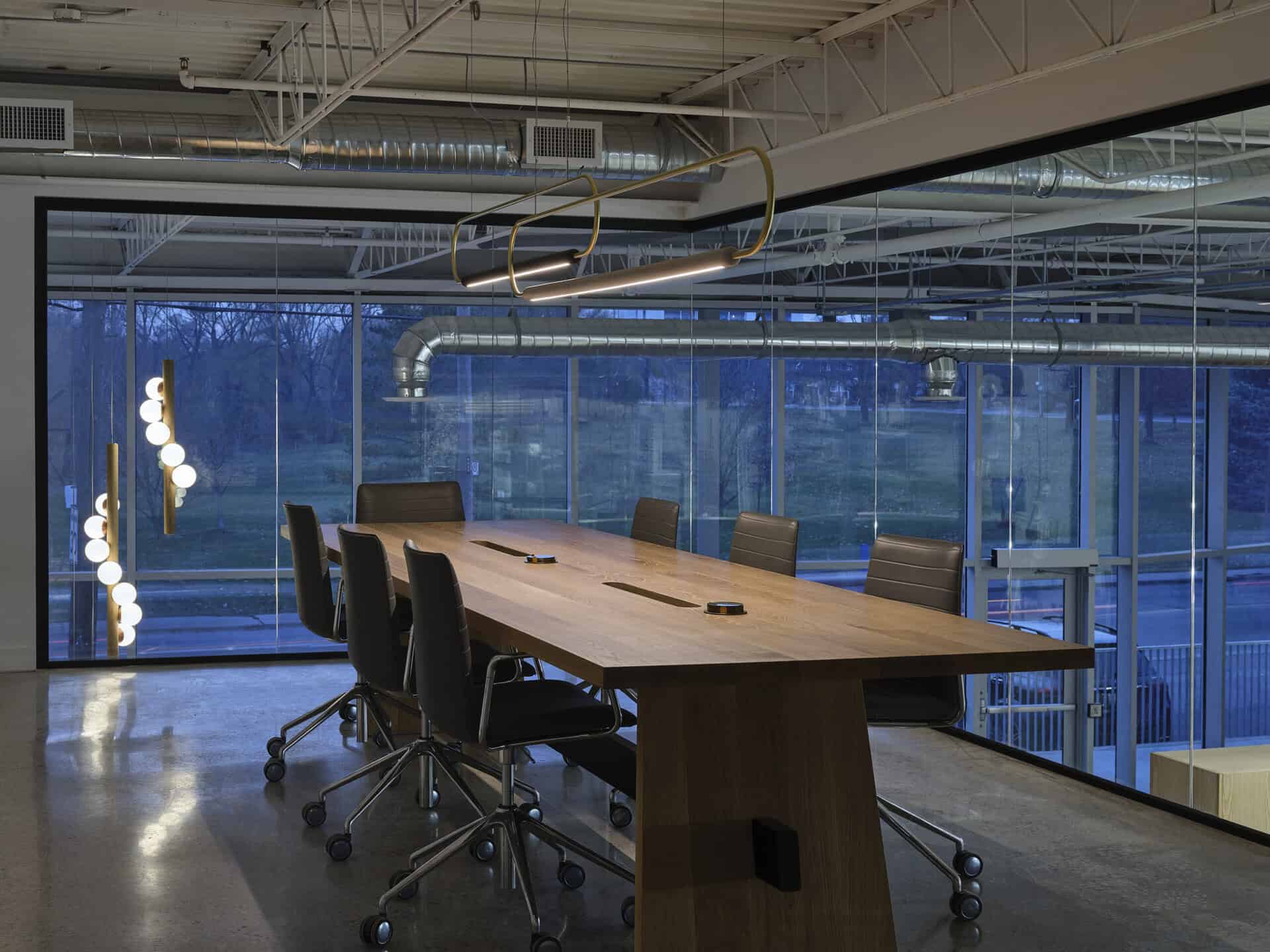 Spacious conference room with glass walls, modern furniture, and professional atmosphere for meeting.